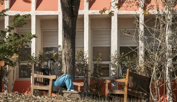 Aluna lendo um livro na PUC Poços.